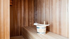 A wooden sauna with benches and a wooden bucket with a scoop. - Ferienhaus in Dagebuell im skandinavischen Stil (Dagebüll)