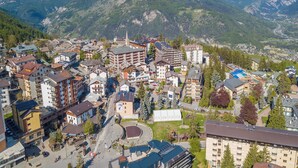 A mountainous town with a mix of residential and commercial buildings, a prominent church, and a winding road.