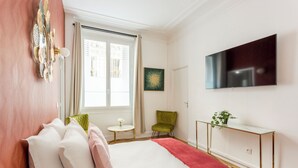 Una camera d'albergo con un letto, una televisione, un tavolino e una sedia.