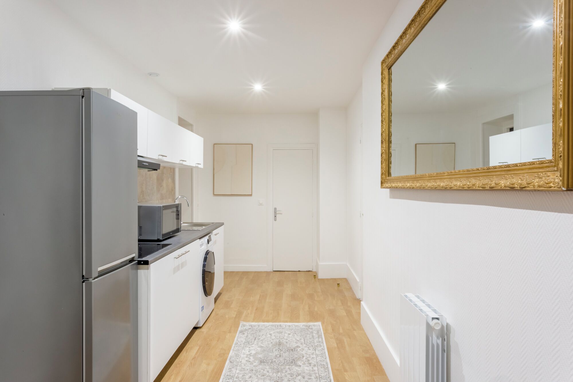 Cocina compacta con refrigerador, microondas y lavadora.