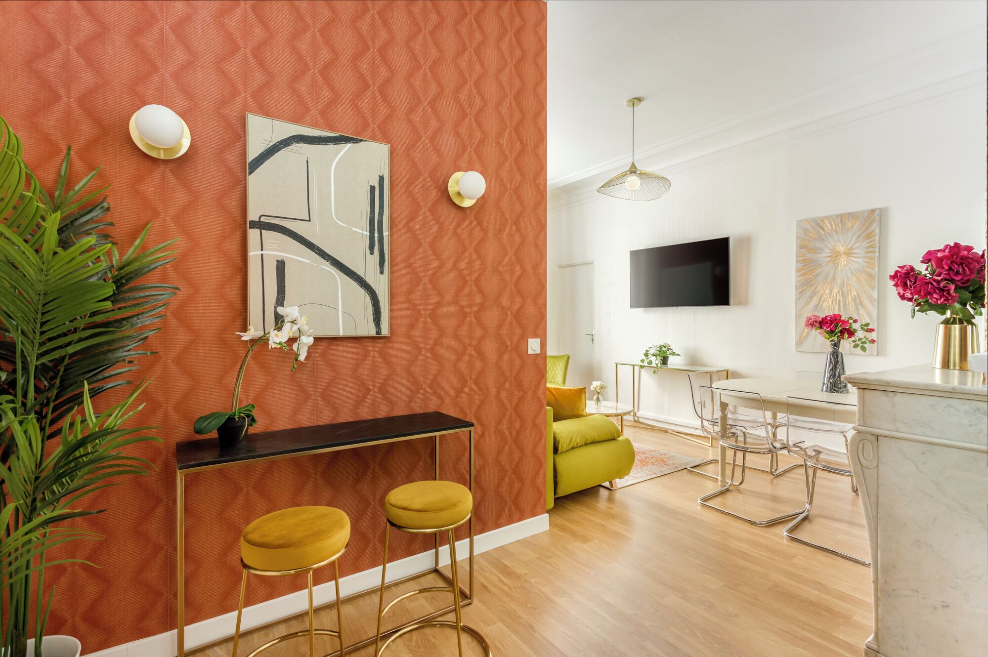 A modern living room with a sofa, a coffee table, and a TV mounted on the wall.