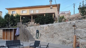 Une terrasse avec des meubles d’extérieur, un foyer et un mur en pierre.