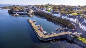 A coastal town with a harbor, boats, and white buildings along the waterfront. - A Coastal Haven at 2 Harbour View (Roundstone)