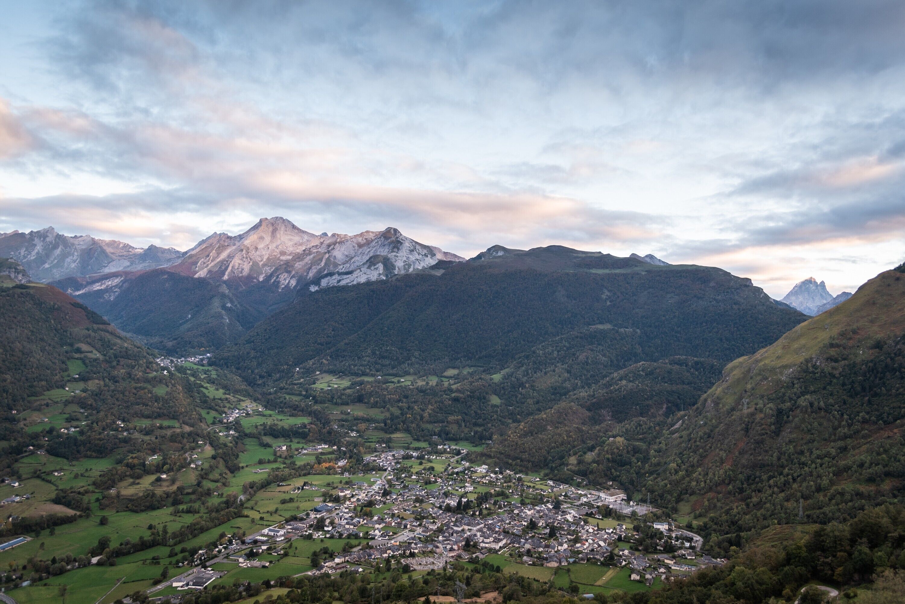 Un paisaje montañoso con un pueblo en el valle.
