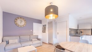Un salon moderne comprenant un canapé, une table à manger et un coin cuisine.