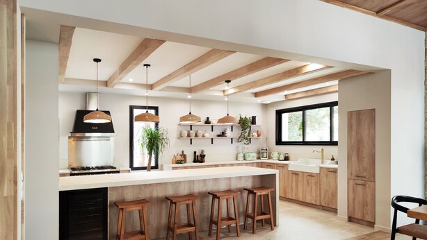 A modern kitchen with wooden beams, a central island with stools, and built-in appliances. - Villa Salicorne 210m2 with swimming pool (Saint-Brevin-les-Pins)