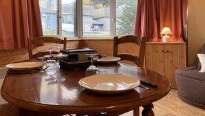 Un coin repas avec une table en bois, des chaises et une lampe.
