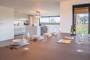 A modern kitchen with white cabinets and a dining area set for a meal.