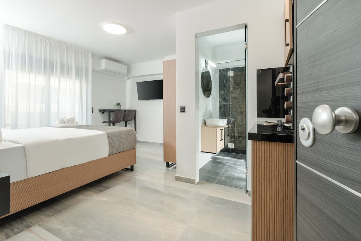 A modern bedroom with a bed, bedside table, and a large window with curtains.