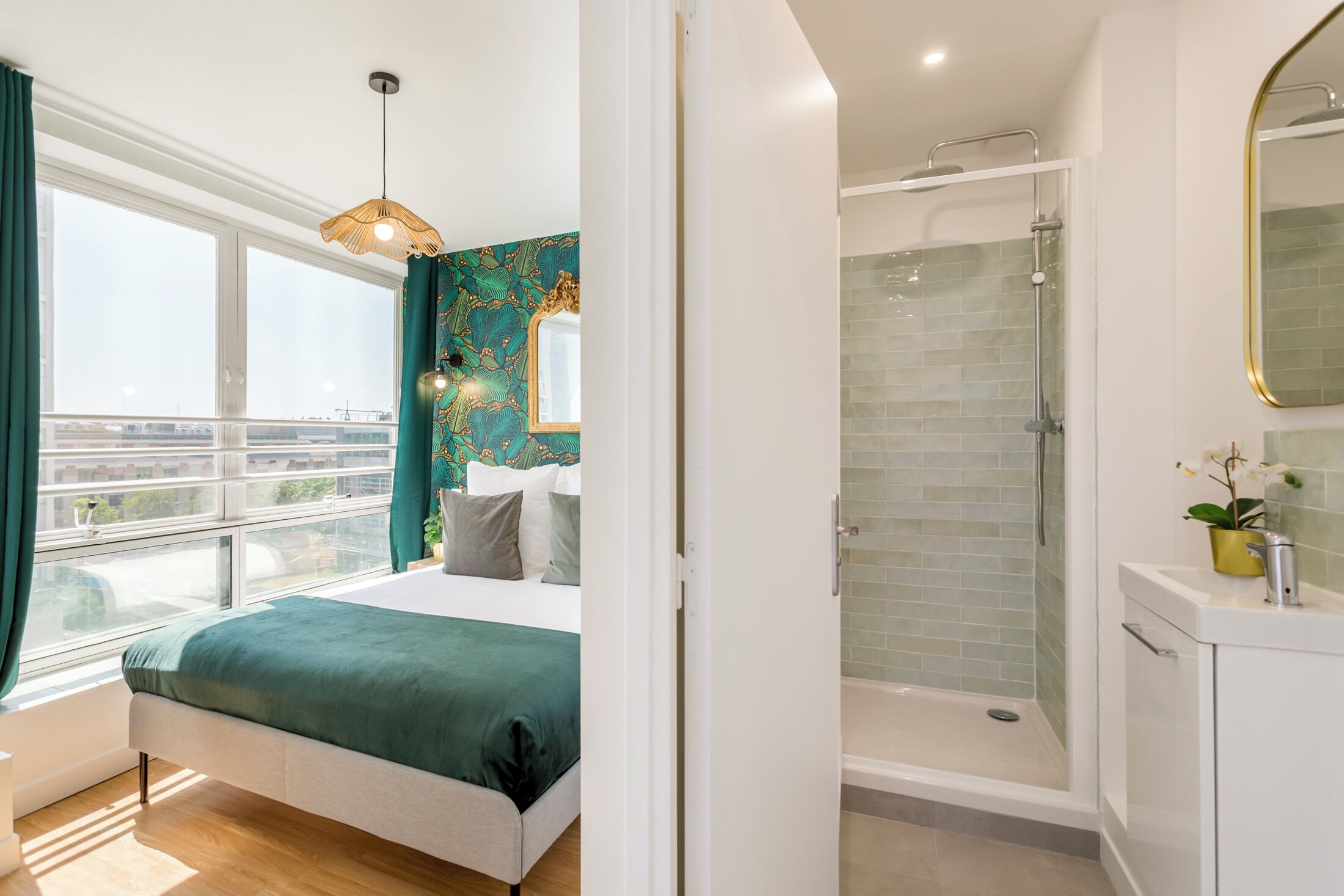Ein modernes Schlafzimmer mit einem großen Bett, einer Dusche und Blick auf die Stadt.