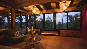 A spacious indoor area with a large window, a fireplace, and a seating area.