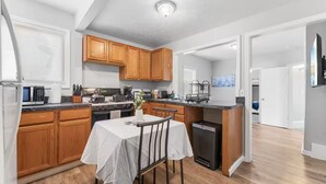 A modern kitchen with wooden cabinets, a dining table, and a built-in oven.
