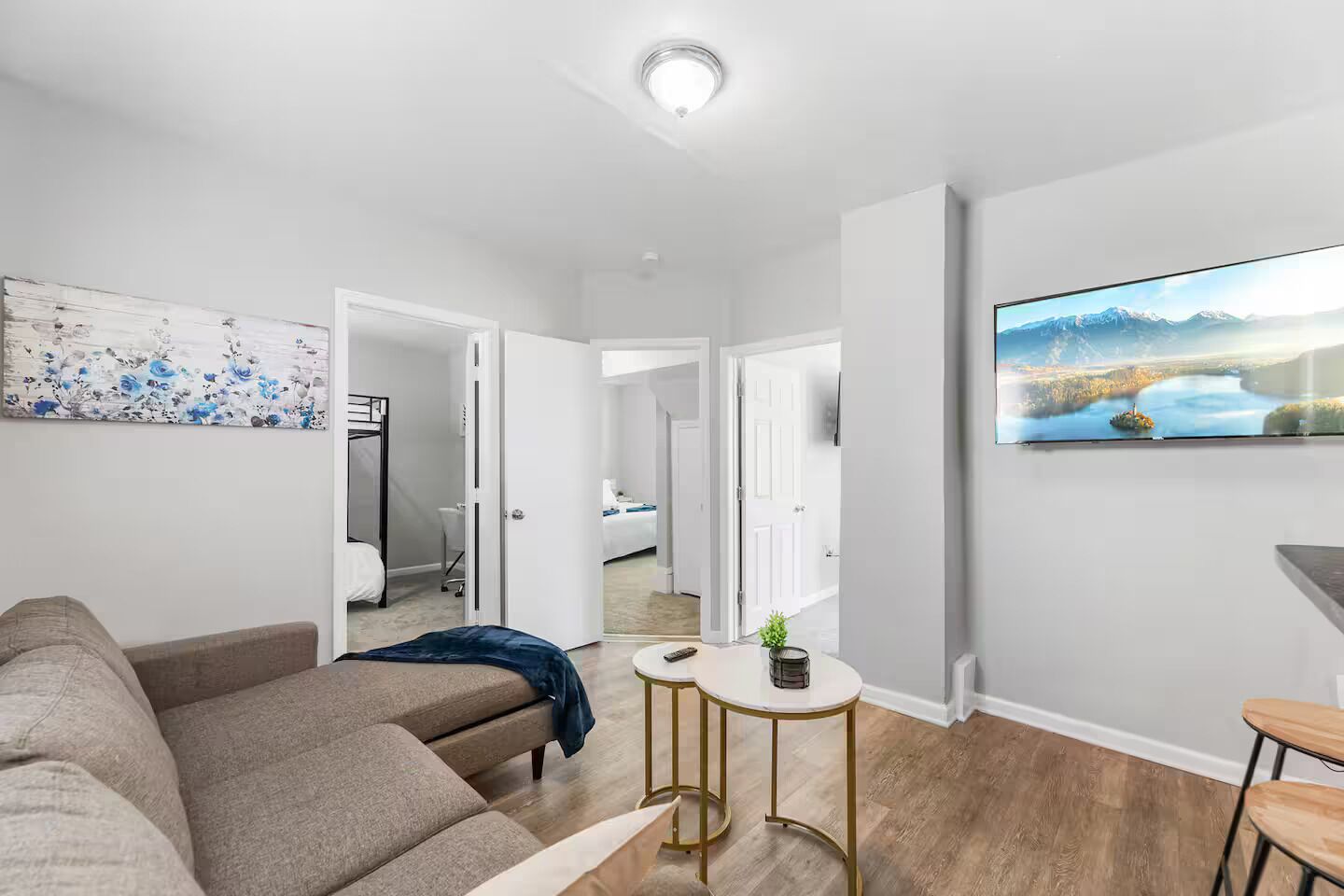 Un salon moderne avec un canapé, une petite table et un tableau accroché au mur.
