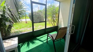 Ein Zimmer mit einem großen Fenster, einem Sessel und einem kleinen Tisch.