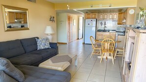 Un salon comprenant un canapé, une table basse et un coin repas avec des chaises et une table.