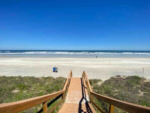 A wooden boardwalk leading to a beach with a clear sky. - Excellent located oceanfront condo at Fourwinds. (St. Augustine)