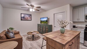 A modern kitchen with a wooden island, white cabinets, and a ceiling fan. - Ruby 207: 1BD | Great LOCATION + Shared Amenities! (Pigeon Forge)