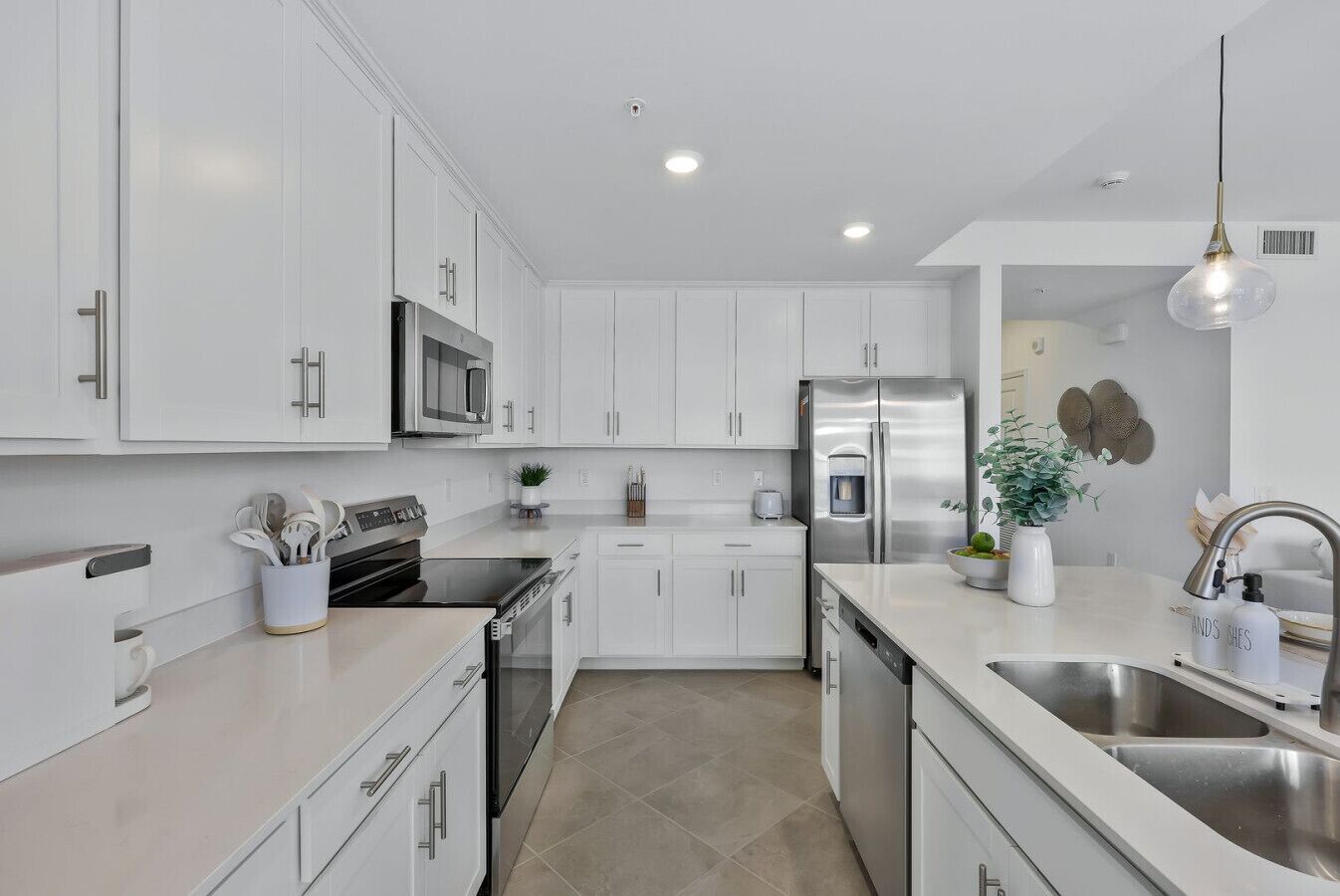 A modern kitchen with white cabinetry, stainless steel appliances, and a clean, minimalist design.