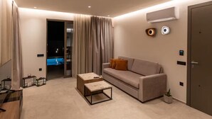 A modern living room with a sofa, coffee table, and a TV.