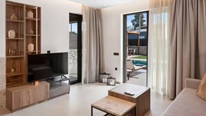 A modern living room with a flat-screen TV, wooden shelving, a sofa, and a coffee table.