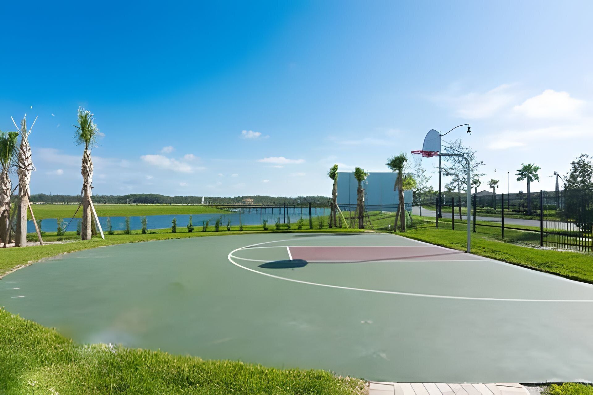 An outdoor basketball court with a water body in the background.