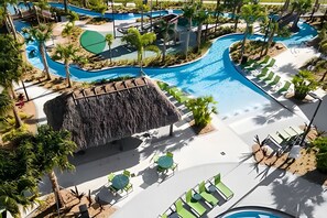A resort pool area with multiple swimming pools, lounge chairs, and a waterfall feature. - 5BR w/ South Pool, Game Room – Storey Lake (Kissimmee)