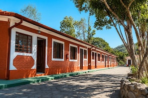 A row of red brick buildings with white trim and green steps, lined with trees. - Hotel Fazenda Águas de Lindóia (Águas de Lindóia)