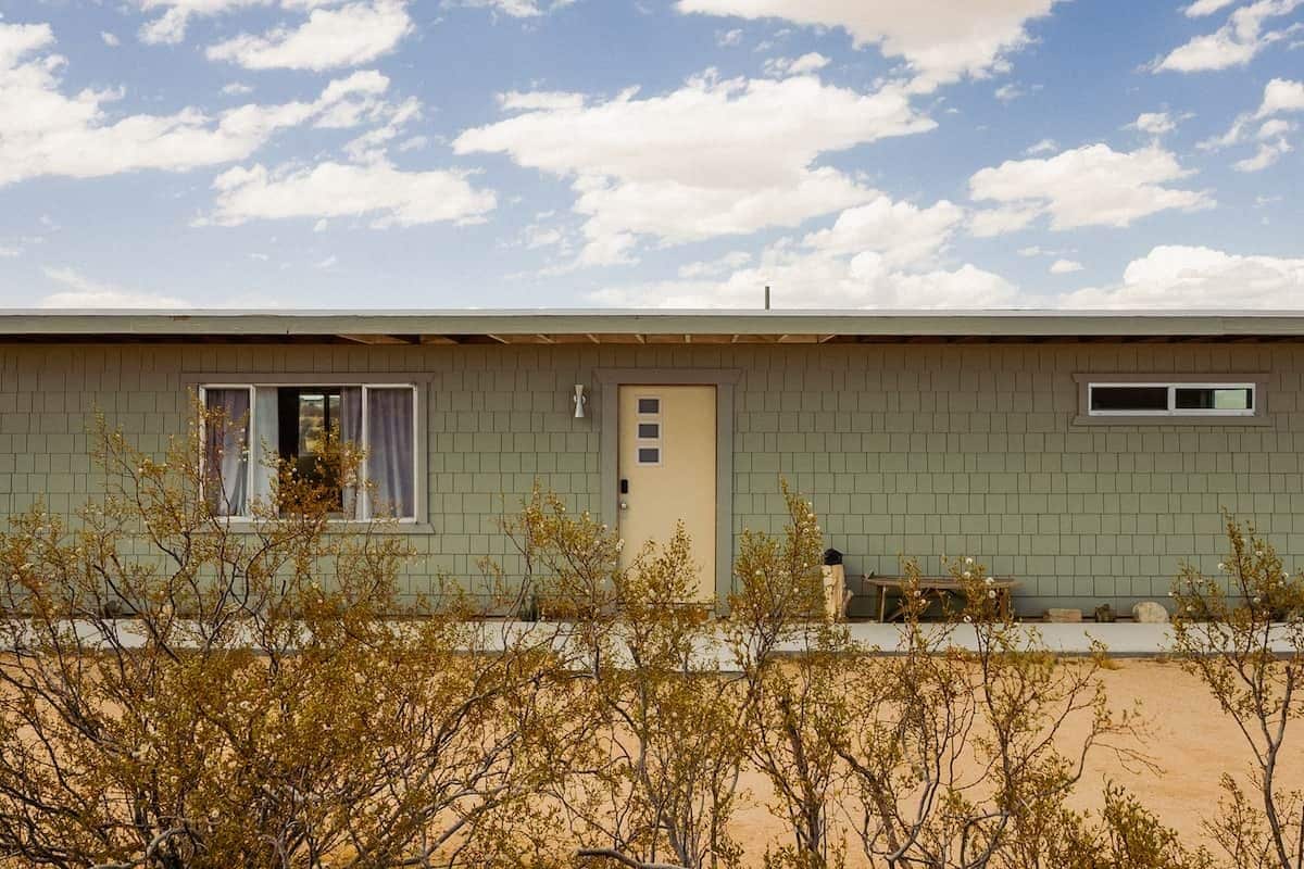 A single-story building with a flat roof, a door, and a window.