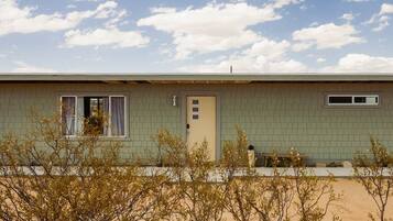 A single-story building with a flat roof, a door, and a window.