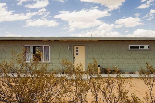 A single-story building with a flat roof, a door, and a window.