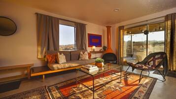 A living room with a sofa, a coffee table, a patterned rug, a chair, and a fireplace.