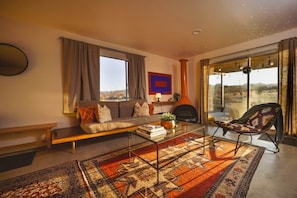 A living room with a sofa, a coffee table, a patterned rug, a chair, and a fireplace.