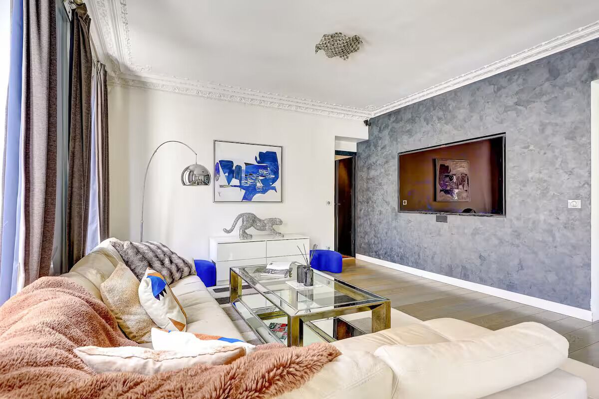 A living room with a sofa, coffee table, and artwork on the wall.