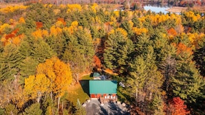 An aerial view of a cabin surrounded by a forest with autumn foliage. - Kavanagh Bay Resort|Hot Tub&Sauna #1 (Hayward)