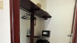 A room with a wooden door frame, a tiled floor, a shelf with a radio, and a hanging coat rack. - Marvelous 3-bedroom Apartment in Villa, Beautiful Pool, Steps from Surf & Ocean (Atlantic Shores)