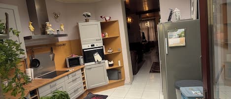Et moderne køkken med ovenlys, træskabe, et køleskab og et spiseområde med bord og stole.