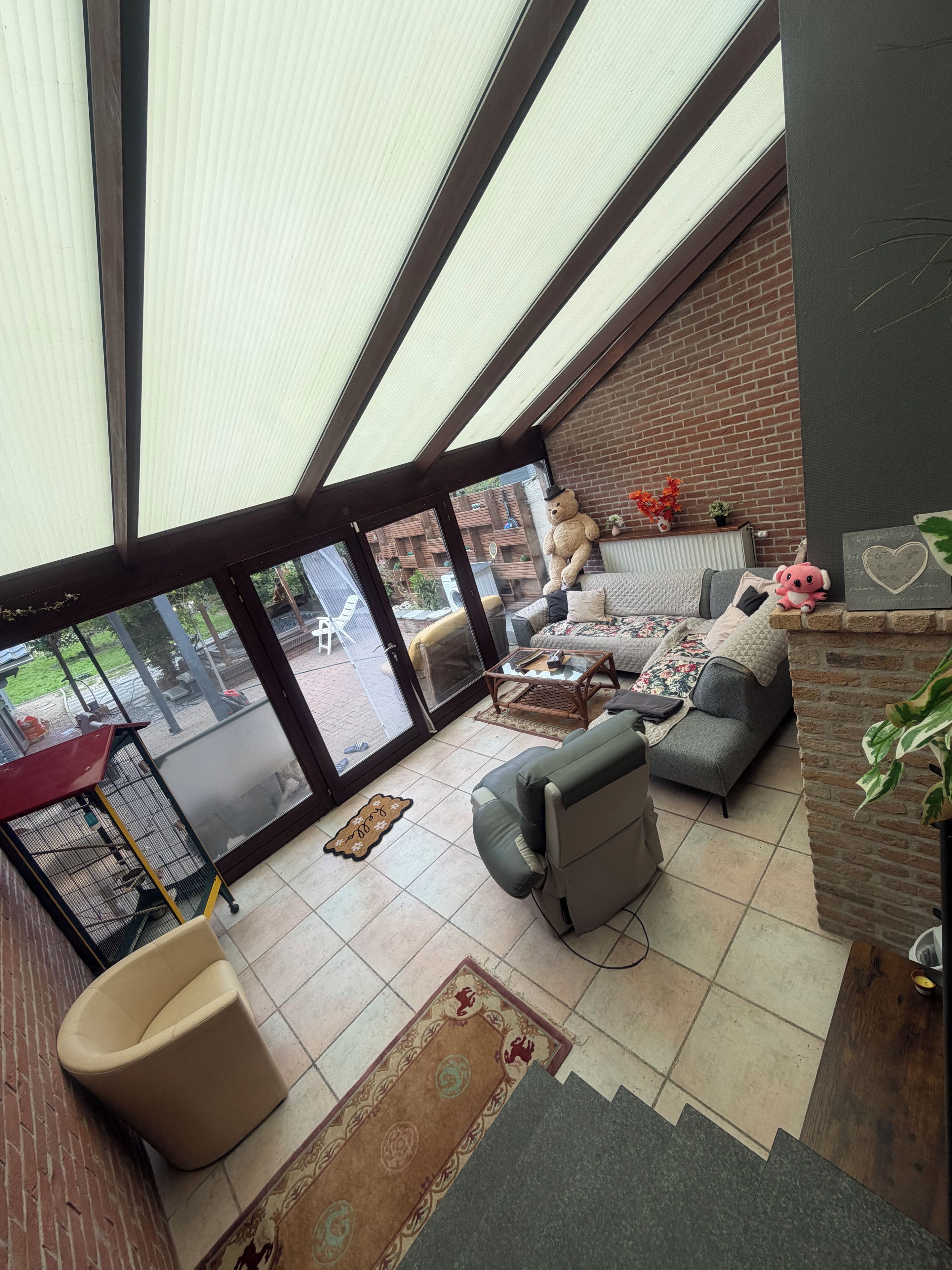 A spacious living area with a large window, a sofa, a coffee table, and a pet bed.