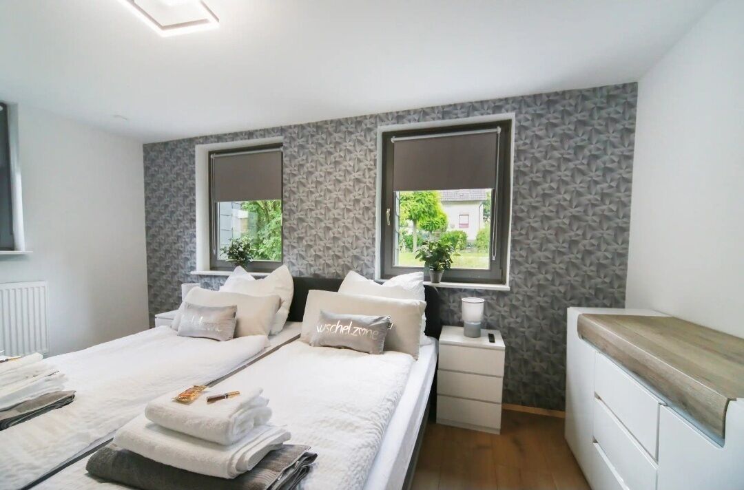 Camera moderna con un letto grande, comodini e vista sul verde.