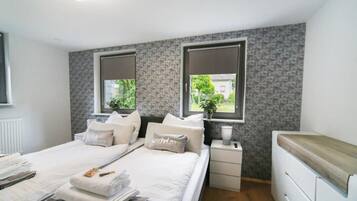 Camera moderna con un letto grande, comodini e vista sul verde.