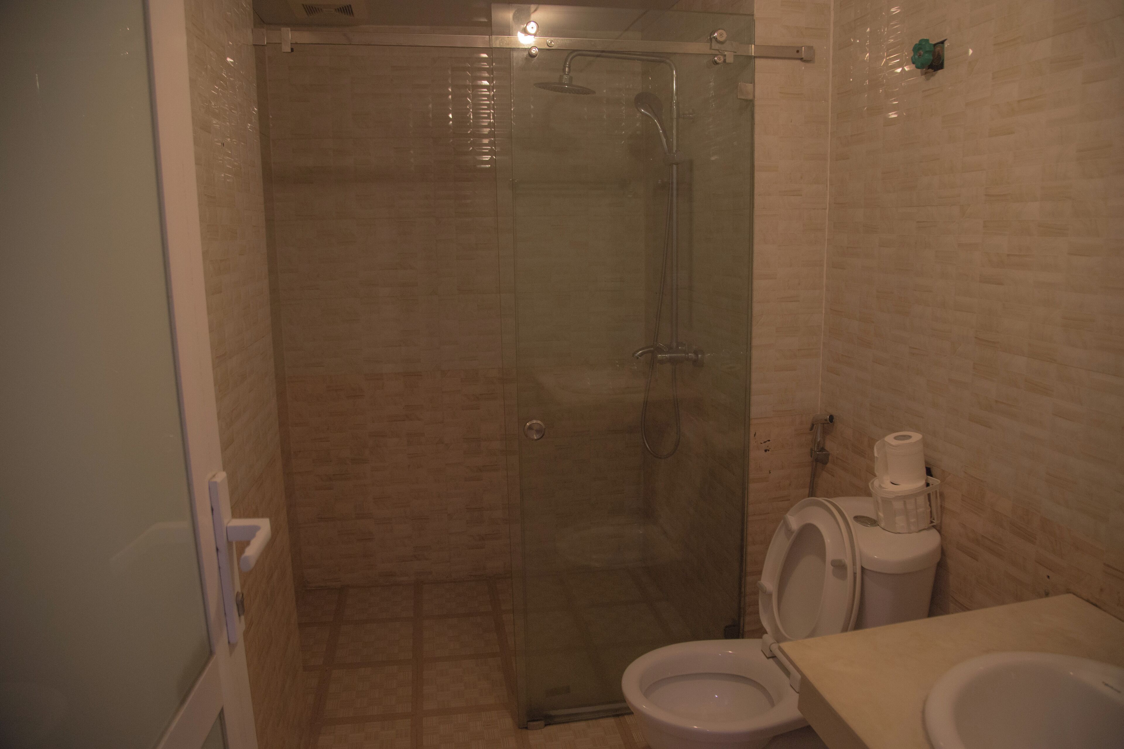 Un baño con ducha de vidrio, inodoro y lavabo.