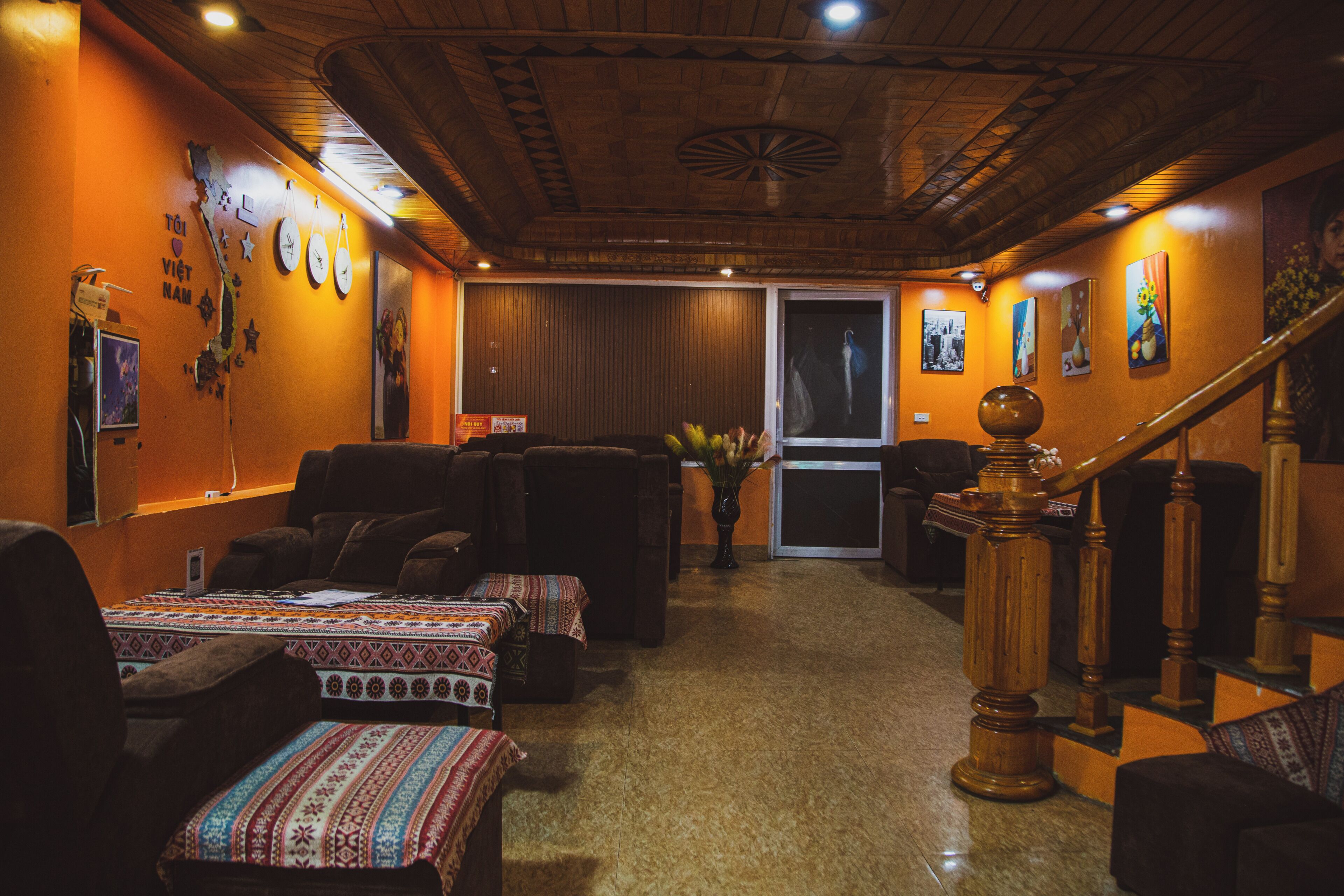 A cozy interior with a wooden ceiling, a staircase, and a seating area with sofas and a table.