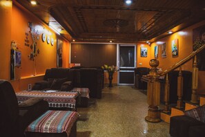 A cozy interior with a wooden ceiling, a staircase, and a seating area with sofas and a table. - Sapa Central House (Sa Pa)