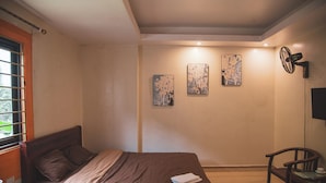 A bedroom with a bed, a chair, and artwork on the wall. - Sapa Central House (Sa Pa)