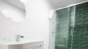 A modern bathroom with a white vanity, a toilet, and a glass shower enclosure. - Pairc House Hotel (Birmingham)