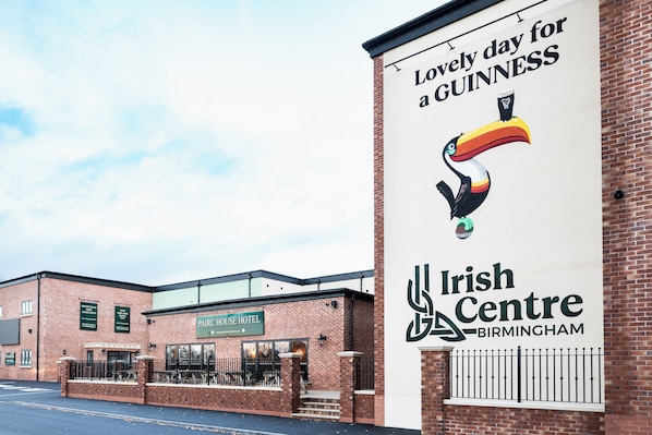 A brick building with a sign for the Irish Centre Birmingham and a Guinness advertisement. - Pairc House Hotel (Birmingham)