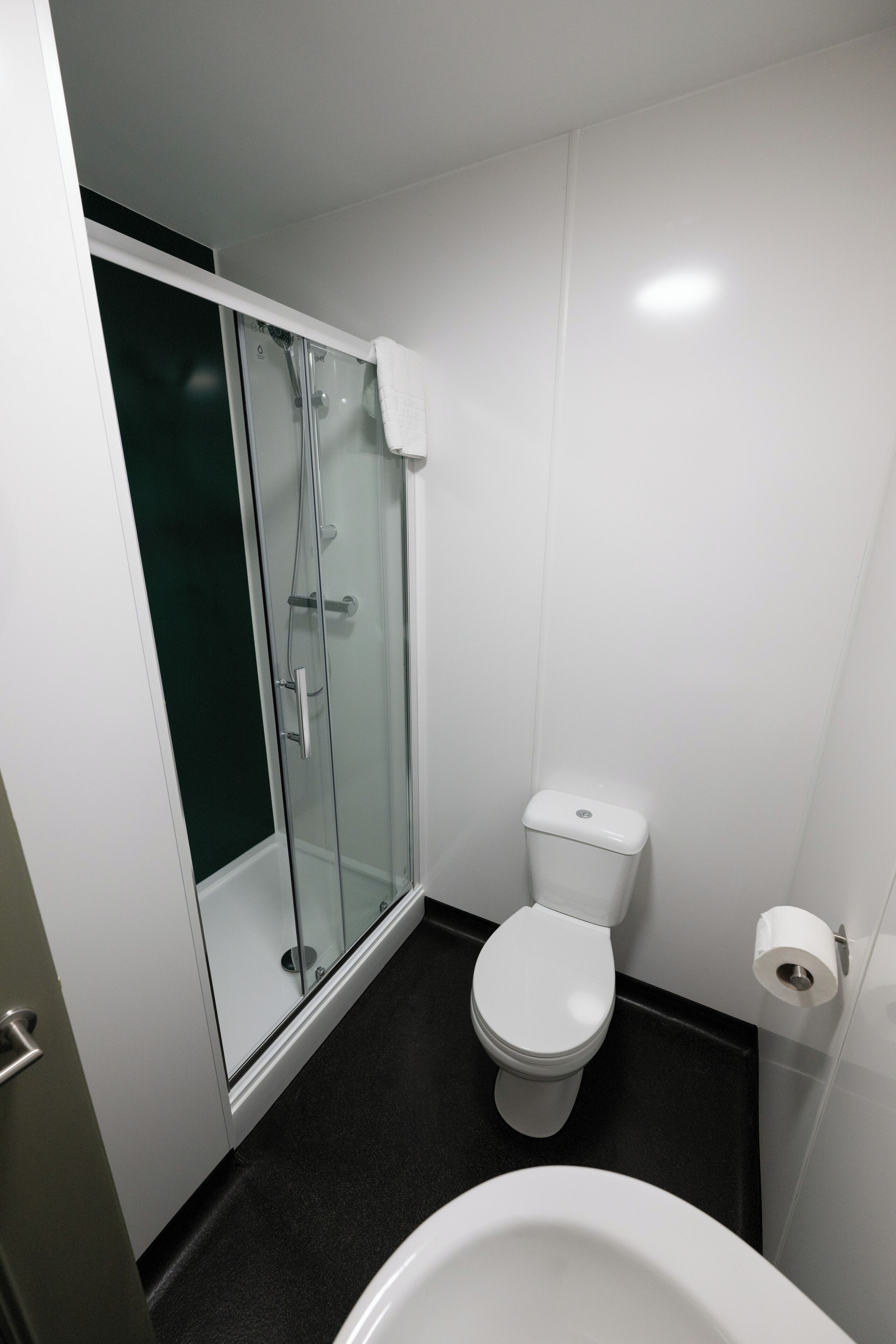 A modern bathroom with a glass shower enclosure, a white toilet, and a bathtub.