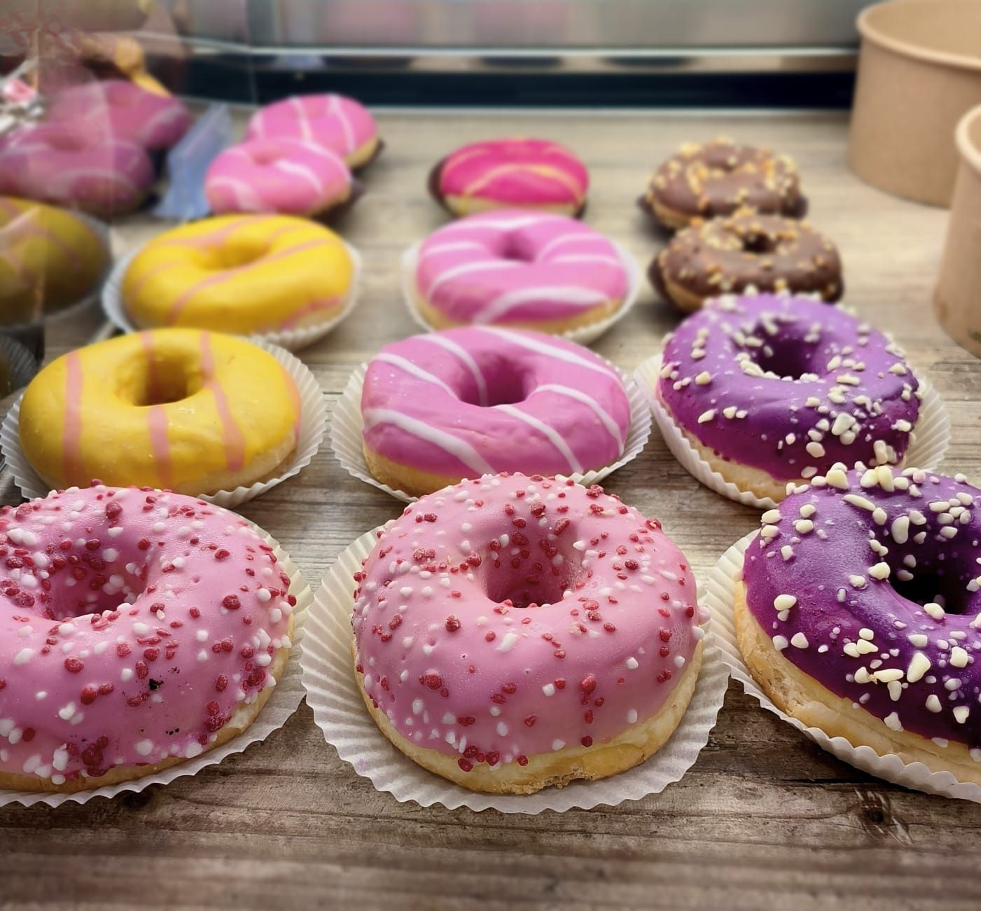 A variety of donuts arranged on a wooden surface.