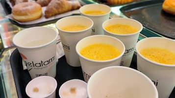 Una bandeja con varias tazas de café y una variedad de pasteles.
