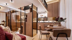 Un interior moderno con un sofá, sillas, una mesa de comedor y una zona de cocina.