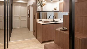 Una cocina moderna con armarios de madera, encimera de mármol y un lavabo integrado.